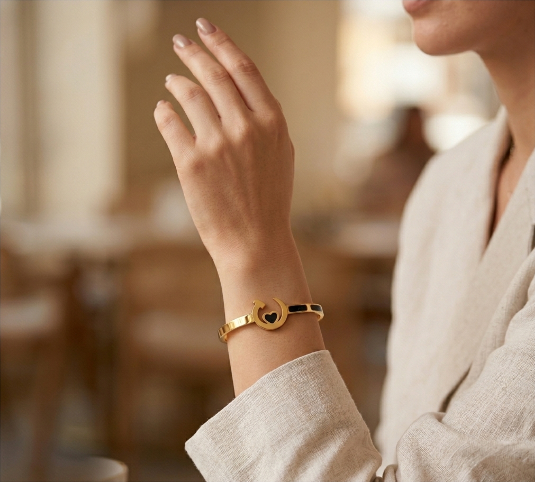 Woman's minimal gold bracelet with black heart design, elegant everyday jewellery look